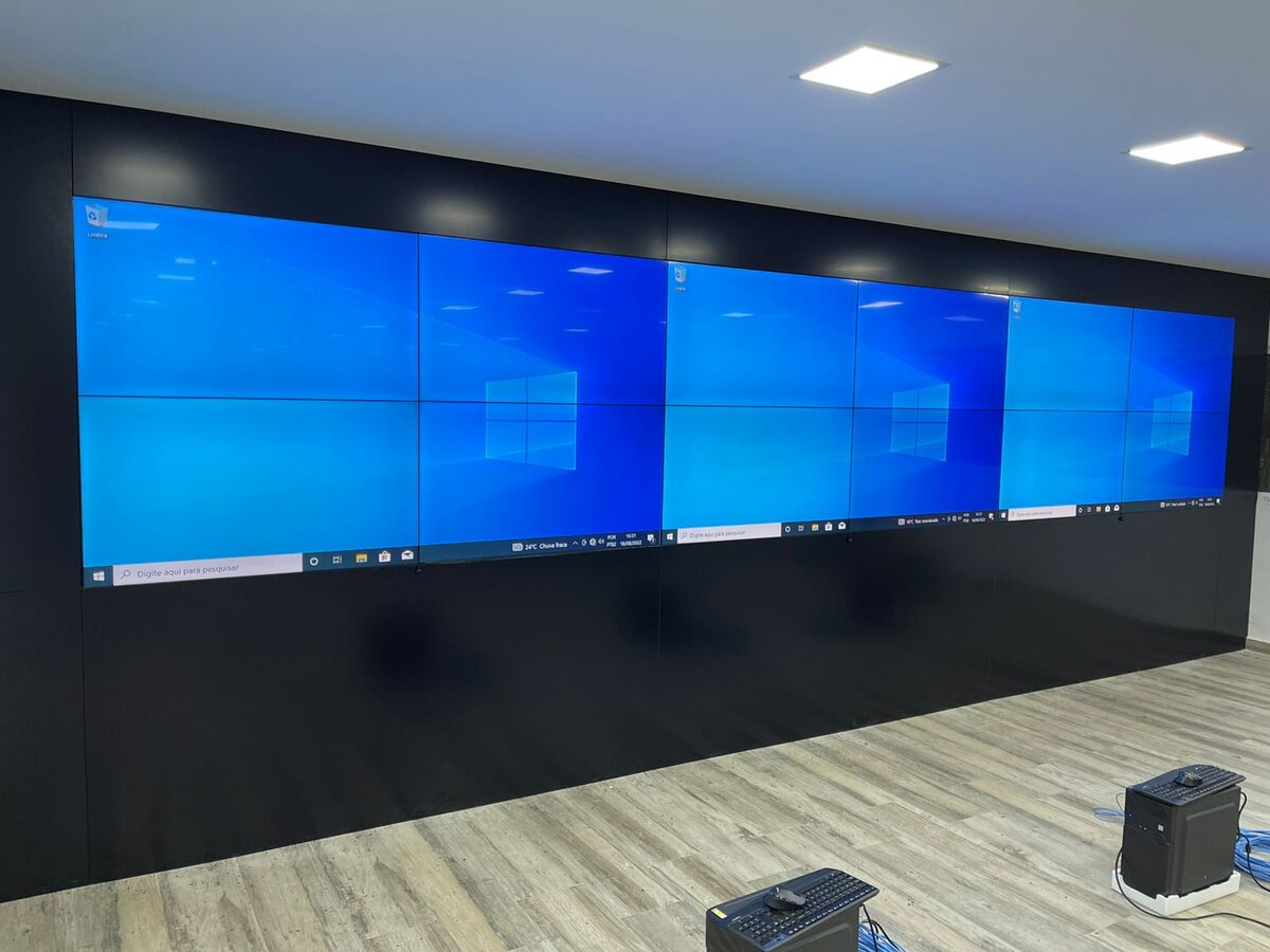 Sala de reunião executiva com integração de áudio profissional, vídeo wall e videoconferência
